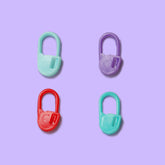 Four kynova positioning lock accessories for crochet, in red, green, purple, and blue colors, displayed on a purple background.